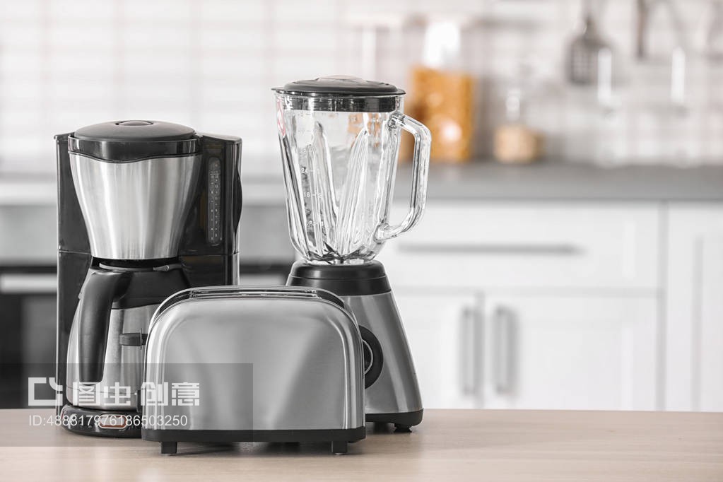背景模糊的餐桌上的厨房电器Kitchen appliances on table against blurred background